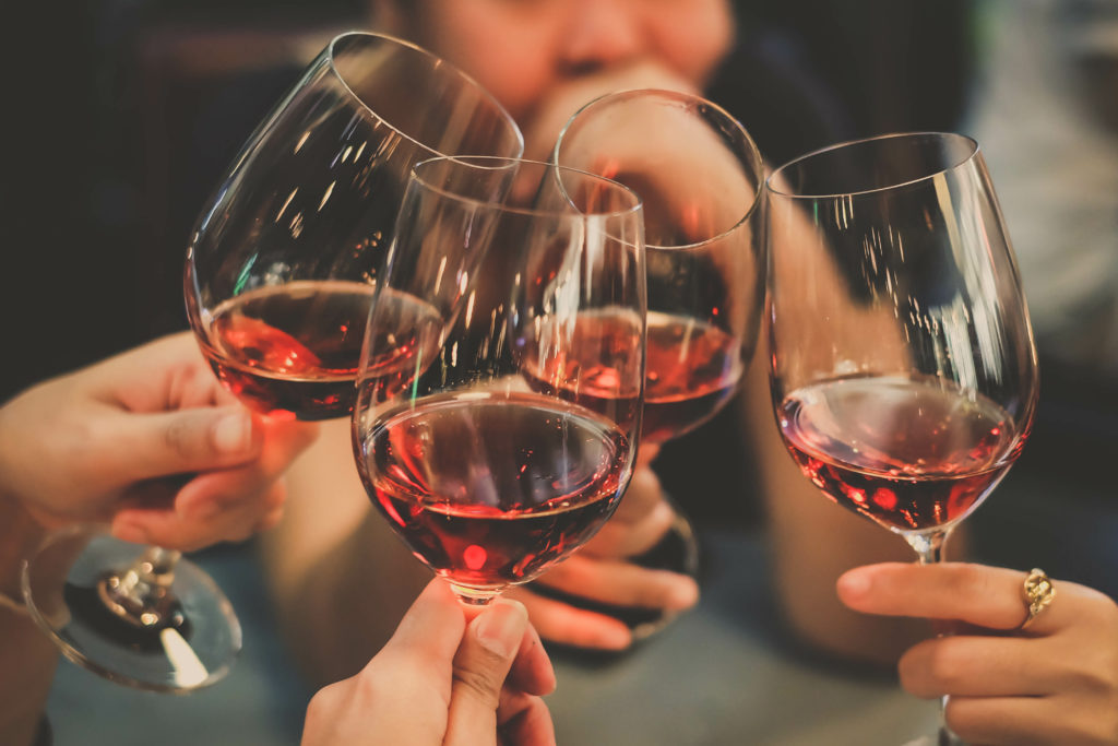 Close up of group of people clinking their wine glasses together