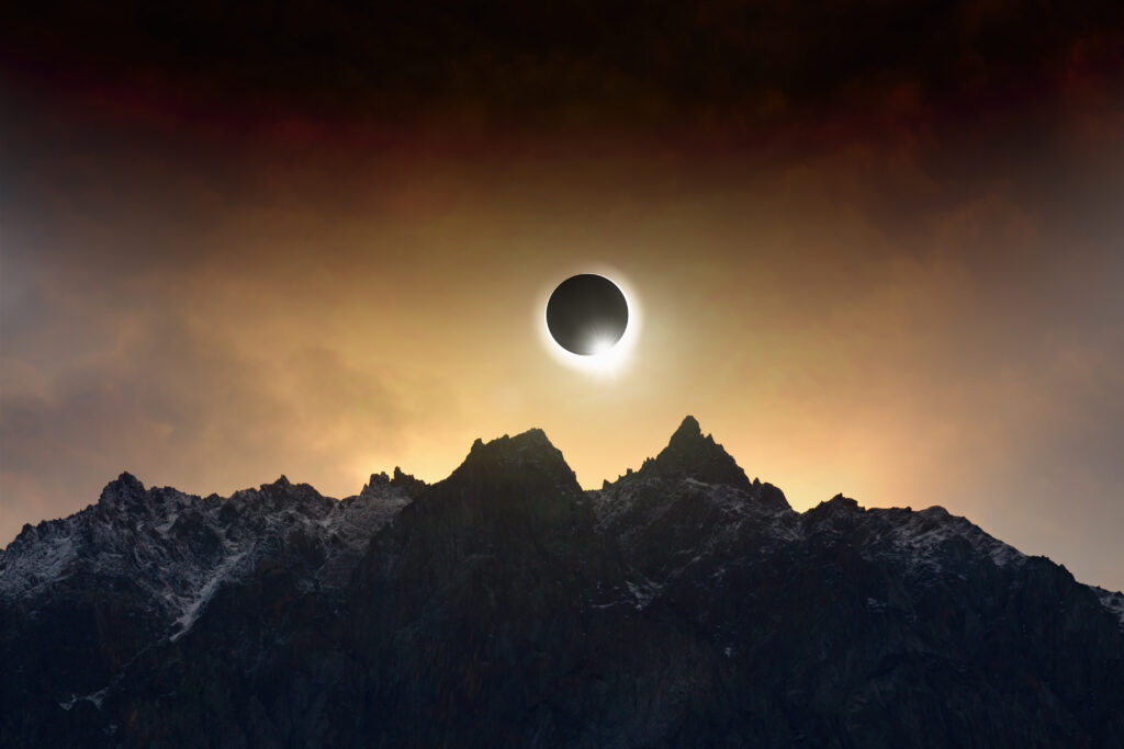 Total solar eclipse rising above a mountain range