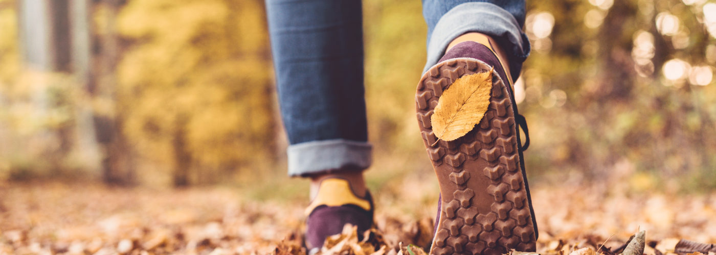 Close up of feet walking away from camera in a fall forest