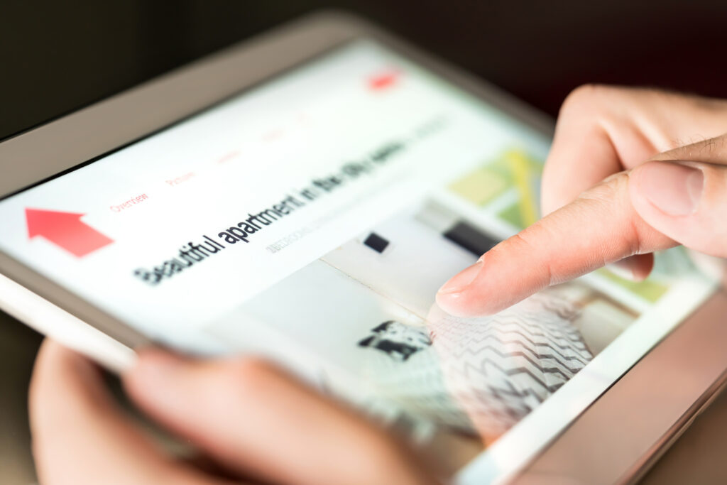 Close up of person using iPad to search through apartment listing