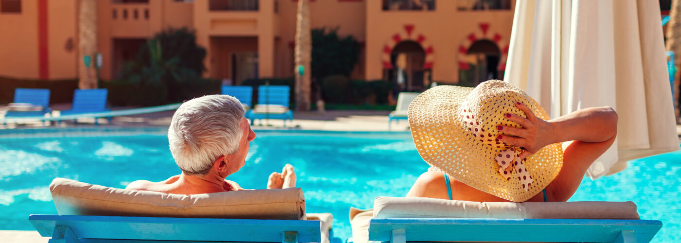 Senior couple relaxing by the pool at an all-inclusive resort