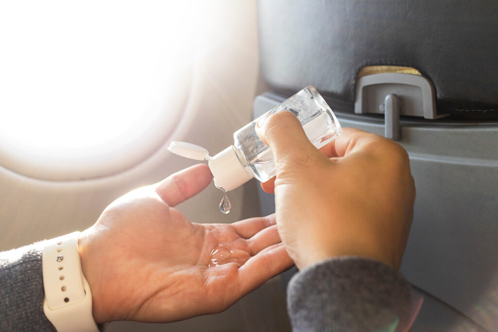 Close up of person's hands as they apply hand sanitizer from a clear bottle