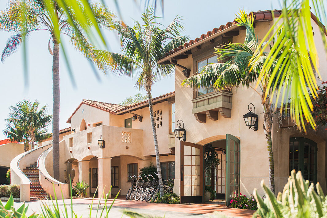 Exterior of Brisas del Mar, Inn at the Beach surrounded by palm trees on a sunny day