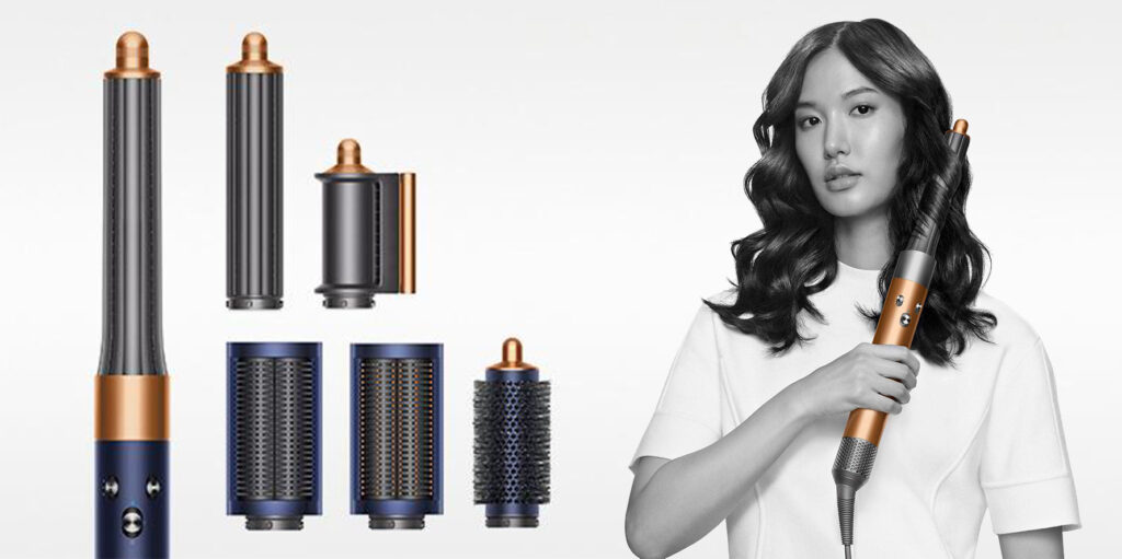 Multiple pieces of the Dyson Airwrap Hair Styler, displayed next to a women styling her long hair with the Dyson Airwrap Hair Styler